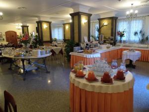 un gran salón de banquetes con mesas y platos. en Residence Le Nereidi, en La Maddalena