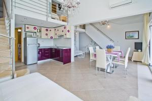 a kitchen and dining room with purple cabinets and a table at Island Hvar Seaside Villa Levanda with Beach, Pool & Seaview in Hvar