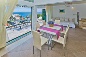 jadalnia ze stołem i krzesłami oraz balkonem w obiekcie Island Hvar Seaside Villa Levanda with Beach, Pool & Seaview w Hvarze