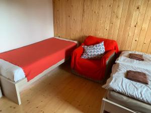ein Zimmer mit einem Bett und einem roten Stuhl darin in der Unterkunft Chata u Zámku in Stráž nad Nežárkou