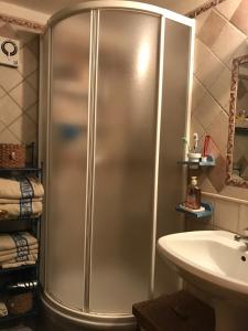 une douche dans une salle de bains avec lavabo et toilettes dans l'établissement Stintino casa con giardino vicino la Pelosa, à Stintino