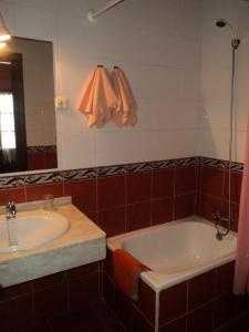 y baño con bañera, lavabo y espejo. en Hotel Rural La Casona del Fraile, en Colunga