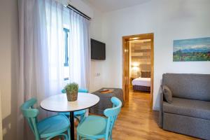 a living room with a table and chairs and a couch at Kibbutz Malkiya Travel Hotel in Malkiyya