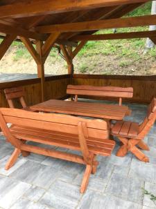 two picnic tables and a bench under a gazebo at Apartmán 17 Romantika Chopok Juh Tále in Tale