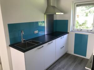 a kitchen with a black counter top and a sink at Villa Oscar with sauna in Winterswijk in Winterswijk