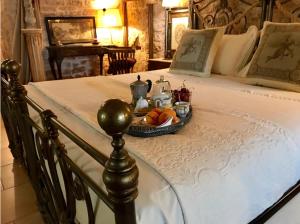 a bed with a tray of fruit on it at Maison Santarosa in Castellana Grotte