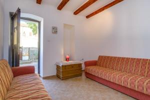 a living room with two couches and a candle on a table at House Sara in Ilovik