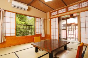 uma sala de jantar com uma mesa e duas janelas em Sansou Nagisa em Isehara