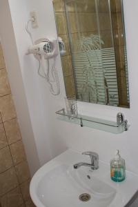 a bathroom sink with a hair dryer and a mirror at Casa La Flori in Techirghiol +50 photos