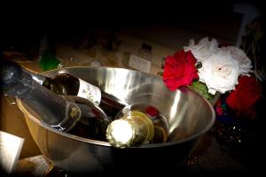 a metal bowl with two bottles of wine and flowers at Casa La Flori in Techirghiol