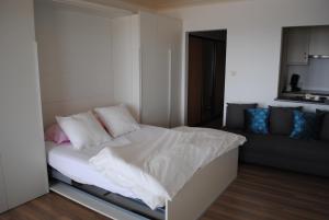 a small bedroom with a bed and a couch at De Zee in Ostend