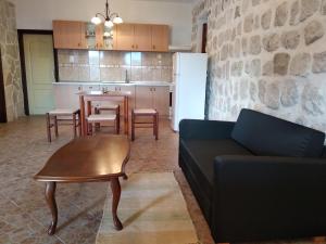 a living room with a couch and a table and a kitchen at Old House Perast in Perast