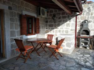 a table and chairs on a patio with an oven at Old House Perast in Perast