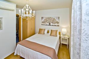 Schlafzimmer mit einem Bett und einem Kronleuchter in der Unterkunft Luxurious Apartments Maslina with Beach in Hvar