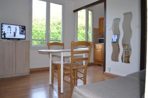 uma cozinha e sala de jantar com mesa e cadeiras em Studio à 100 mètres des thermes vue sur montagne. em Amélie-les-Bains-Palalda