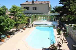 a swimming pool in front of a house at Domaine des Goudis in Bouisse
