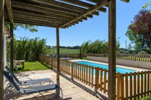 a patio with a wooden pergola and a swimming pool at Mas Nofre in Vilademuls