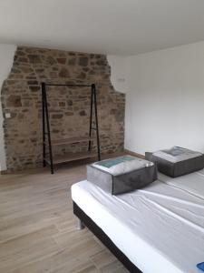 1 Schlafzimmer mit 2 Betten und Ziegelwand in der Unterkunft Gîte des Ayrifagnes in Theux