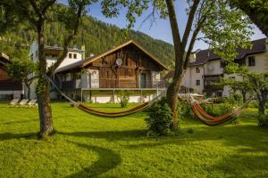 eine Hängematte vor einem Haus mit Bäumen in der Unterkunft Stadlchalet in Ried im Oberinntal