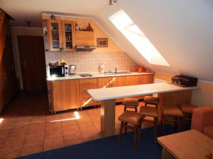 a kitchen with a table and some chairs in it at Apartmány v Terchovej in Terchová