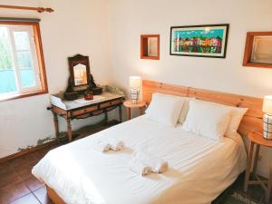 a bedroom with a bed with towels on it at Casa da Balseira in Aveiro