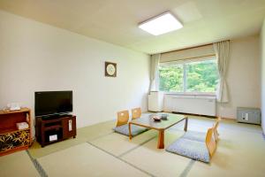 a living room filled with furniture and a tv at Niseko Grand Hotel in Niseko