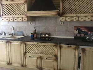 cocina con armarios de madera y encimera negra en Мезонет Мира, en Varna