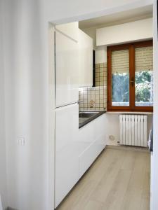 a white kitchen with a refrigerator and a window at CONERO APARTMENT in Castelfidardo
