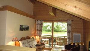 een woonkamer met een bank en een balkon bij Alpine Lodge 8 in Les Contamines-Montjoie