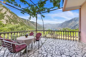 Apartments Vidikovac Inn في كوتور: فناء به طاولة وكراسي وجبال
