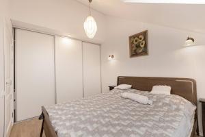 una camera da letto con un grande letto e pareti bianche di Misko Apartaments a Kaunas