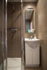 uma casa de banho com um chuveiro, um lavatório e um espelho. em Duplex St Pau em Sant Pau de Segúries
