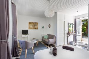 Habitación con cama, sofá y silla en La Ferme de l'Embellie Gîtes et Chambres d'Hôtes, en Le Buisson de Cadouin