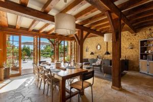 un comedor con una gran mesa de madera y sillas en La Ferme de l'Embellie Gîtes et Chambres d'Hôtes, en Le Buisson de Cadouin