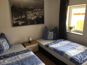a bedroom with two beds and a window at FeWo Altwahnsdorf in Radebeul +1 photo