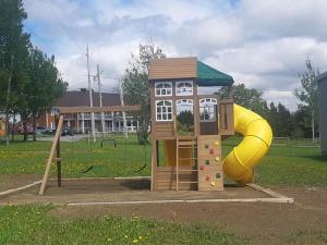 une petite aire de jeux avec toboggan dans un parc dans l'établissement Auberge - Village Grande Nature Chic-Chocs, à Cap-Chat