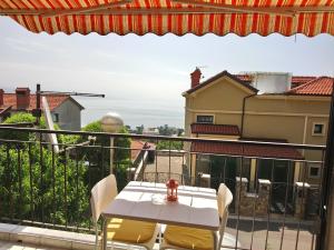 ein Tisch und Stühle auf einem Balkon mit Aussicht in der Unterkunft Charming Hill Apartment in Opatija