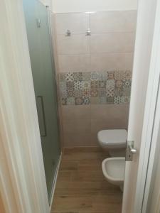a small bathroom with a toilet and a shower at Casa Melograno in Bernalda