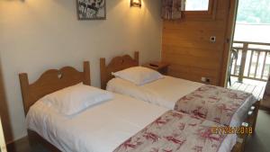 two twin beds in a room with a balcony at Alpine Lodge 7 in Les Contamines-Montjoie