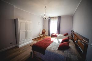 a bedroom with a large bed and a chandelier at BRAIDE Ospitalità Rurale in La Morra