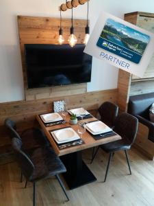 a dining room with a table with chairs and a television at Apartment Luna incl Summercard Zell am See Kaprun in Kaprun