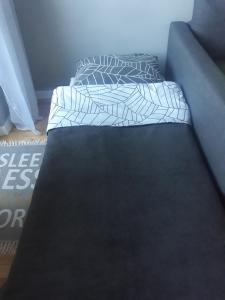 a bed with two pillows on it in a room at Apartament Pod Lasem in Gdańsk