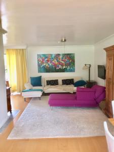 una sala de estar con un sofá púrpura y una pintura en Gaensebluemchen 1 Apartment daisy 1, en Walsdorf