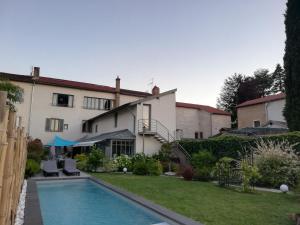 a house with a swimming pool in a yard at De la Chambre au Jardin in Belleville-en-Beaujolais
