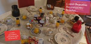 a table with a table cloth with plates and cups at La Ferme De Saint Julien in Charleville-Mézières