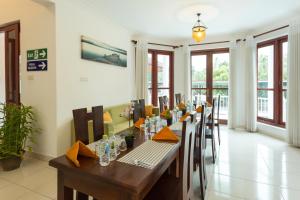 uma sala de jantar com uma mesa longa e cadeiras em Orchid Villa Kandy em Kandy