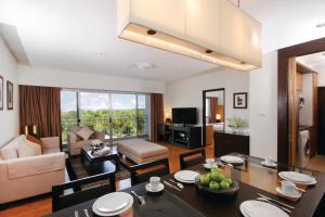 Kantary Hotel Kabinburi في Kabin Buri: غرفة معيشة مع طاولة طعام وغرفة معيشة