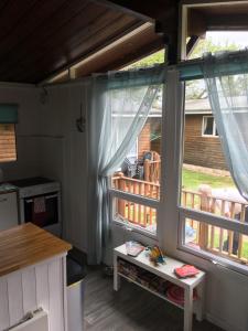 uma cozinha com duas janelas grandes e uma mesa em Chalet 26 em Seaton