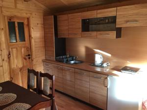 a kitchen with a sink and a microwave and a table at Sielska Chatka Chłopy in Sarbinowo