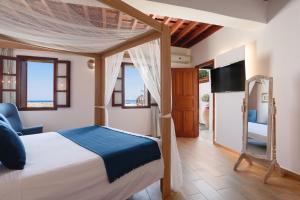 a bedroom with a bed and a tv in a room at Thea Villas and Suite in Lindos